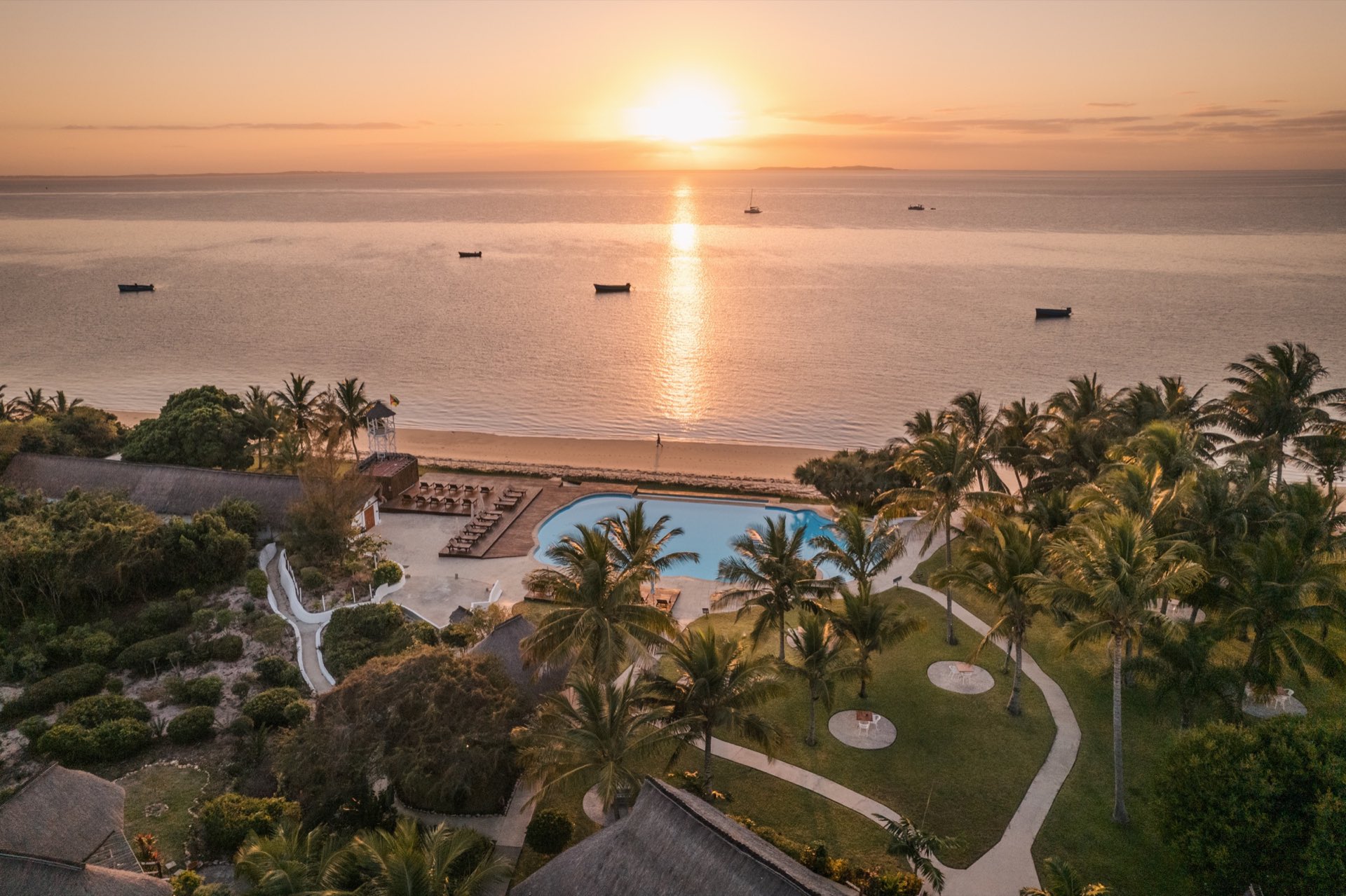 Vilanculos Beach Lodge at sunset: the pool and beachfront looking over the Bay of Vilanculos, fishing boats at anchor offshore.